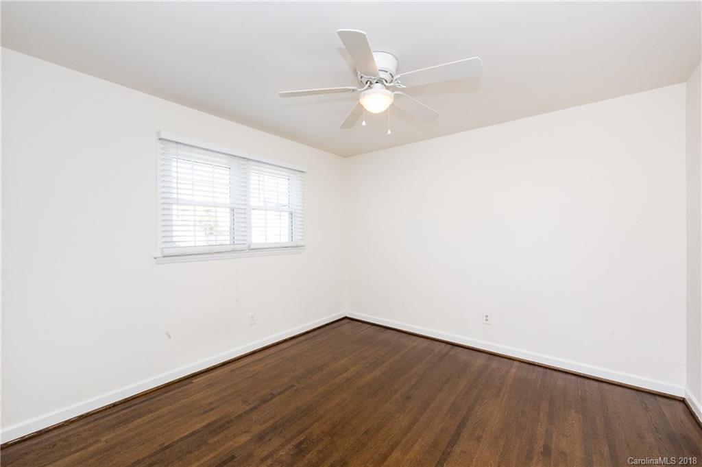 920 McAlway Road, Unit C Charlotte, NC 28211 - Photo 18 of 27 an empty room with wooden floor fan and windows