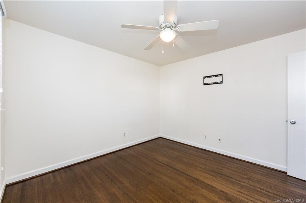 920 McAlway Road, Unit C Charlotte, NC 28211 - Photo 19 of 27 an empty room with wooden floor and fan