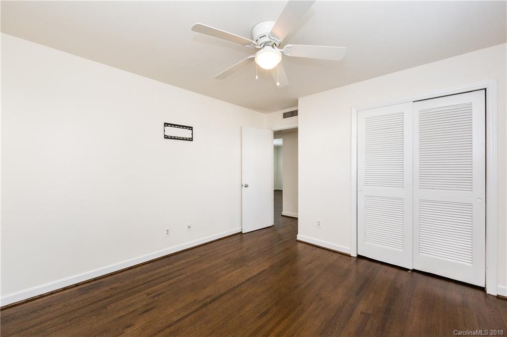 920 McAlway Road, Unit C Charlotte, NC 28211 - Photo 20 of 27 an empty room with wooden floor and fan
