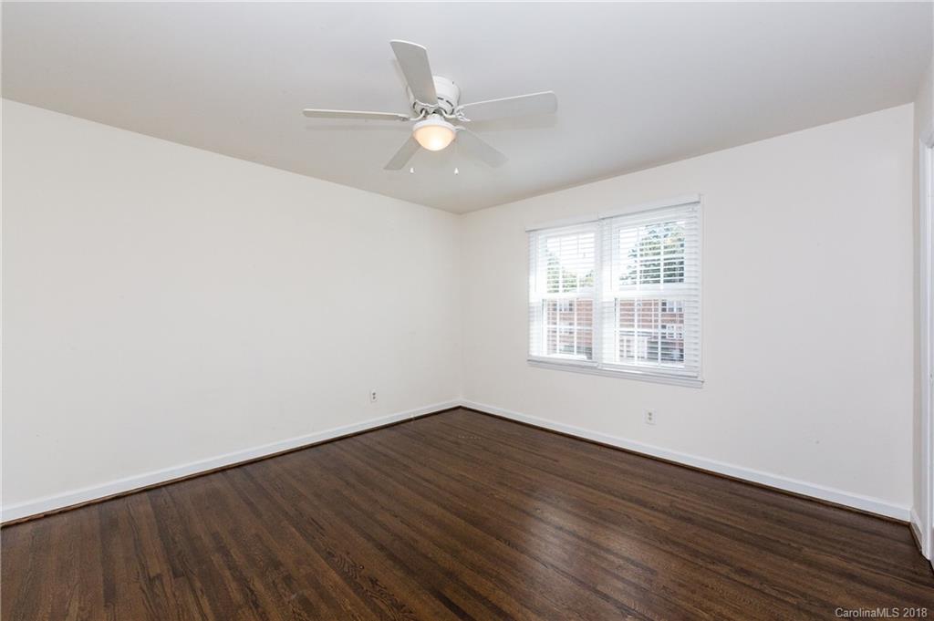 920 McAlway Road, Unit C Charlotte, NC 28211 - Photo 23 of 27 an empty room with wooden floor fan and windows