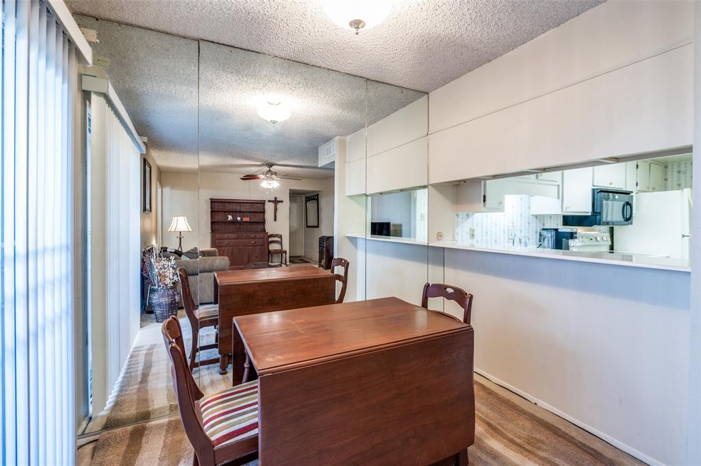 12816 Midway Road, Unit 1066 Dallas, TX 75244 - Photo 12 of 25 a view of kitchen with stainless steel appliances granite countertop sink refrigerator dining table and chairs