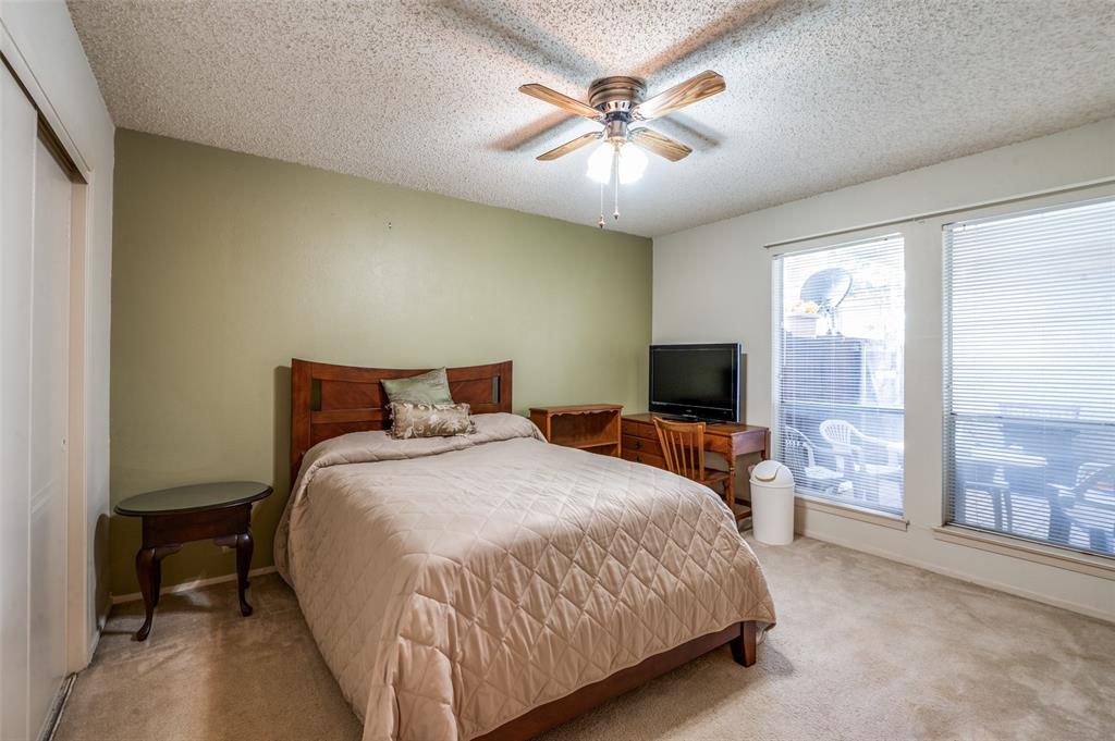 12816 Midway Road, Unit 1066 Dallas, TX 75244 - Photo 15 of 25 a spacious bedroom with a bed and a chandelier