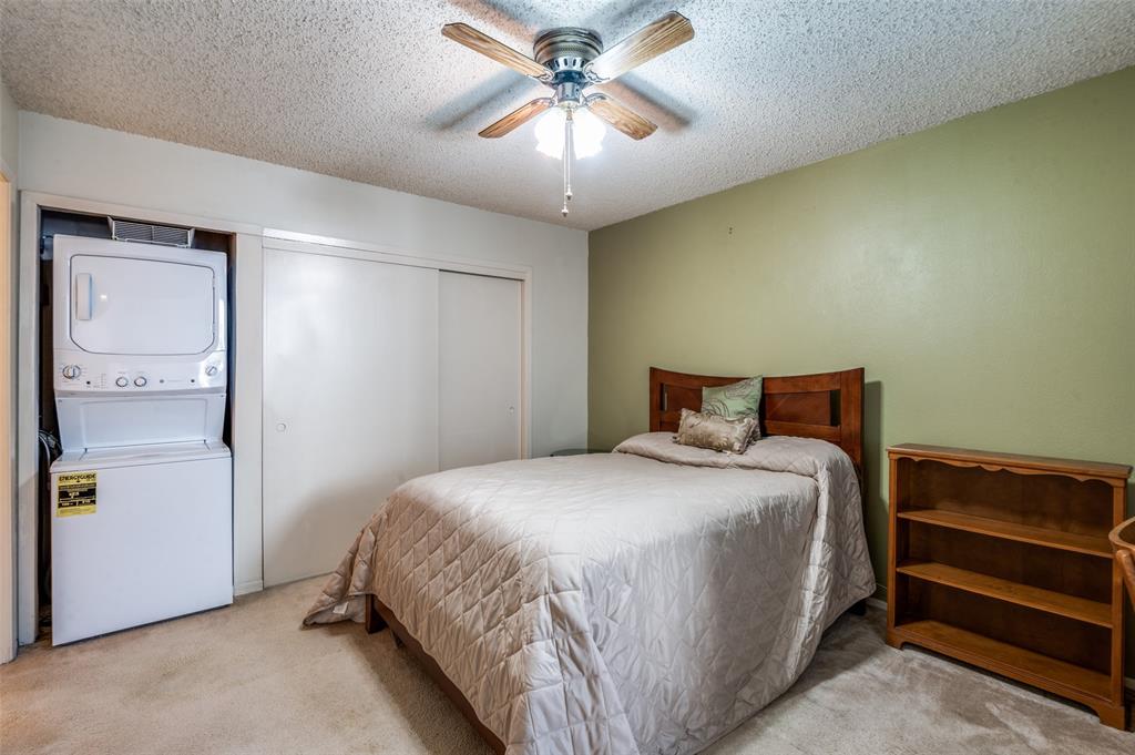 12816 Midway Road, Unit 1066 Dallas, TX 75244 - Photo 16 of 25 a bedroom with a bed and a chandelier