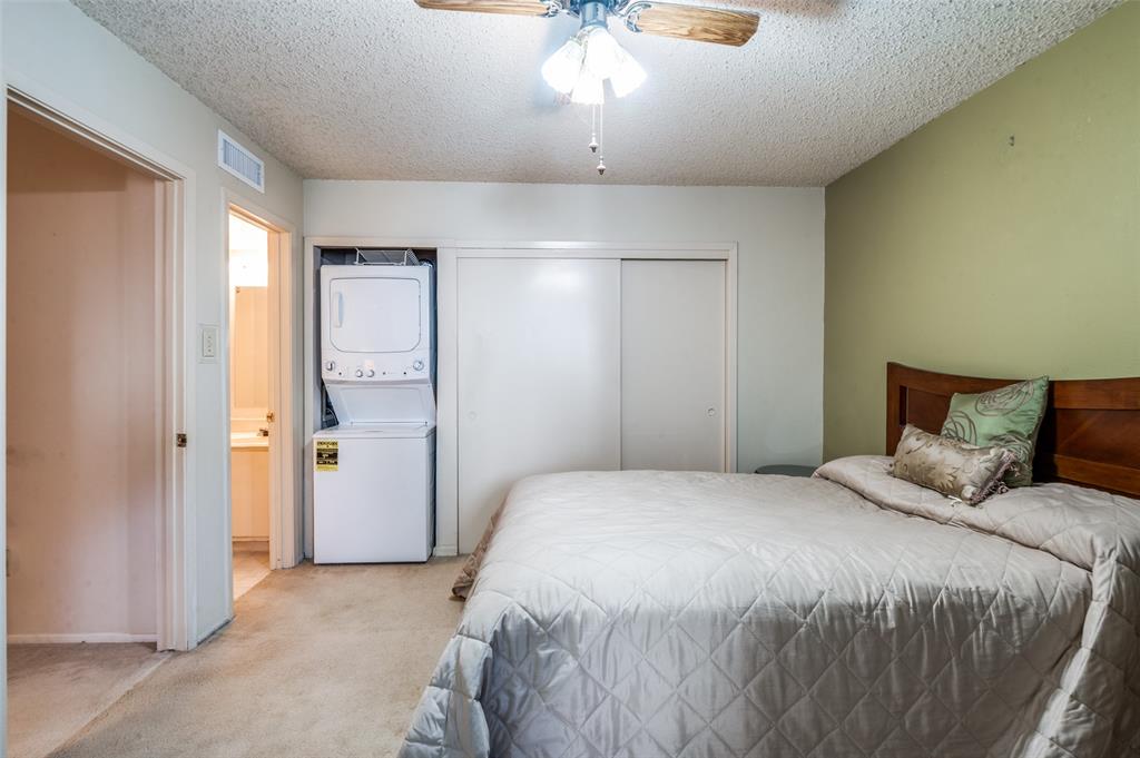 12816 Midway Road, Unit 1066 Dallas, TX 75244 - Photo 17 of 25 a bedroom with a bed and a chandelier