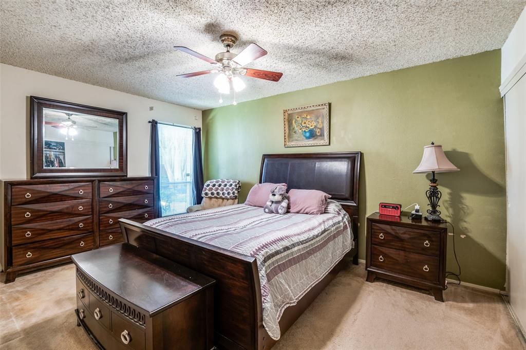 12816 Midway Road, Unit 1066 Dallas, TX 75244 - Photo 18 of 25 a bedroom with a bed and a chandelier