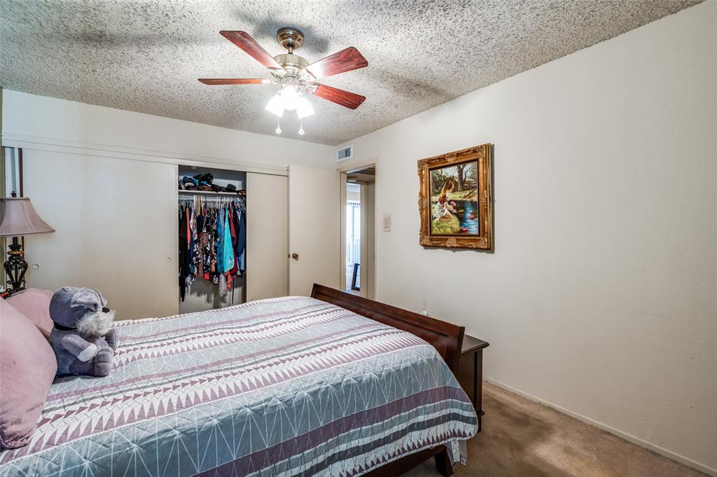 12816 Midway Road, Unit 1066 Dallas, TX 75244 - Photo 20 of 25 a bedroom with a bed and a chandelier