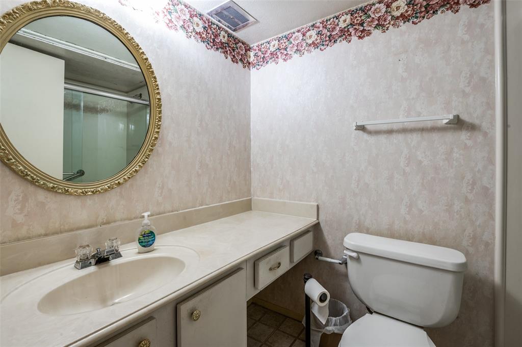 12816 Midway Road, Unit 1066 Dallas, TX 75244 - Photo 21 of 25 a bathroom with a sink mirror vanity and toilet