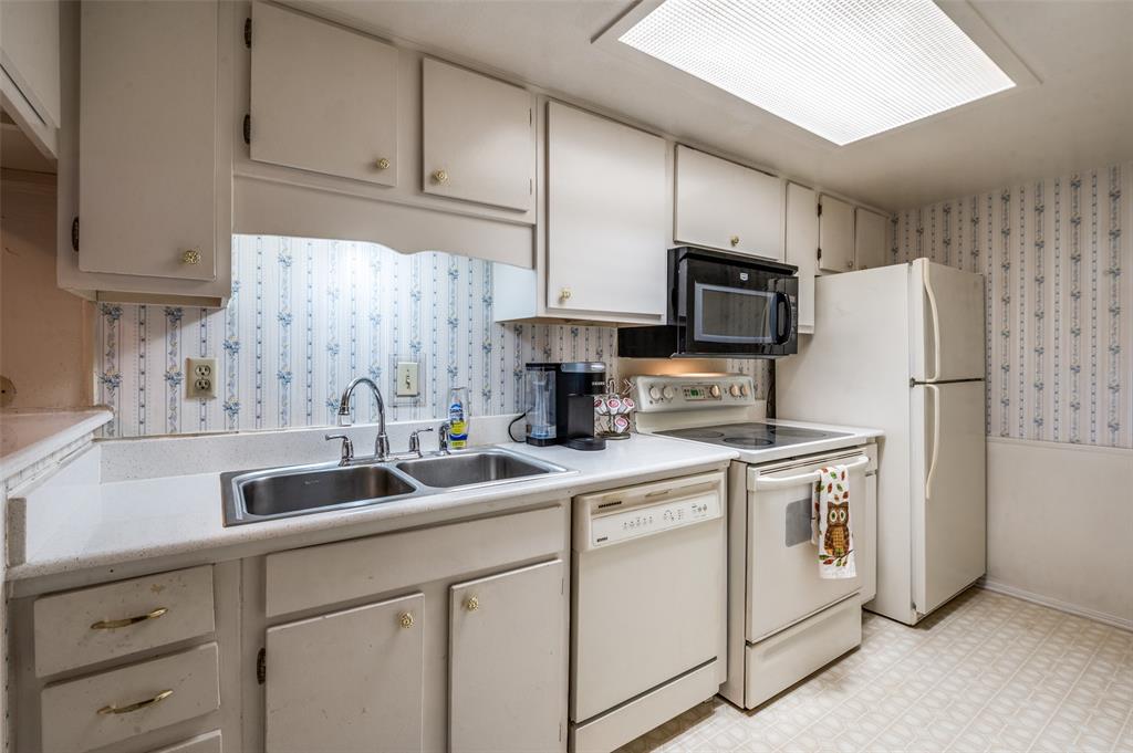 12816 Midway Road, Unit 1066 Dallas, TX 75244 - Photo 8 of 25 a kitchen with white cabinets and refrigerator