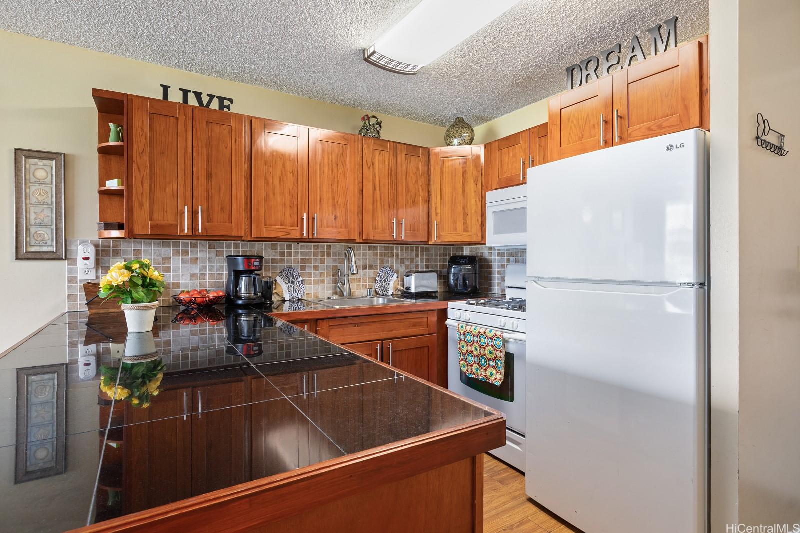 2452 Tusitala Street, Unit 908 Honolulu, HI 96815 - Photo 2 of 19 a kitchen with refrigerator and cabinets