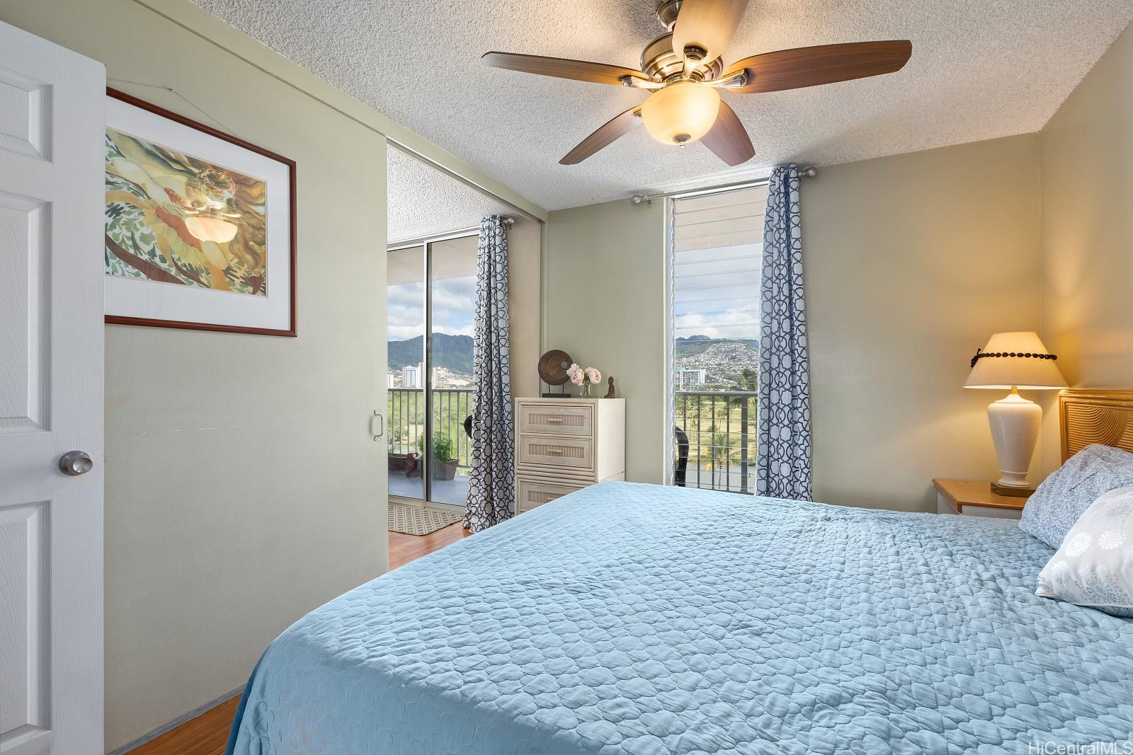2452 Tusitala Street, Unit 908 Honolulu, HI 96815 - Photo 7 of 19 a bedroom with a large bed and a chandelier