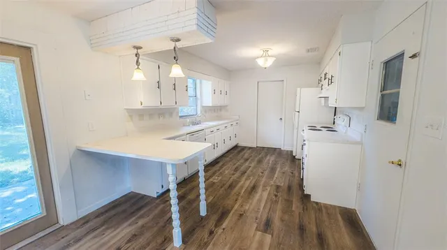 a kitchen with wooden floor sink and refrigerator