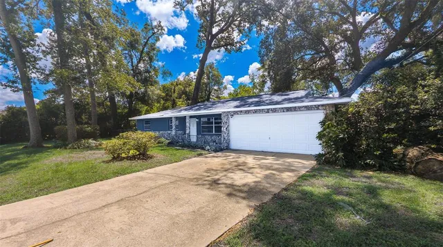 a view of a house with backyard and a tree