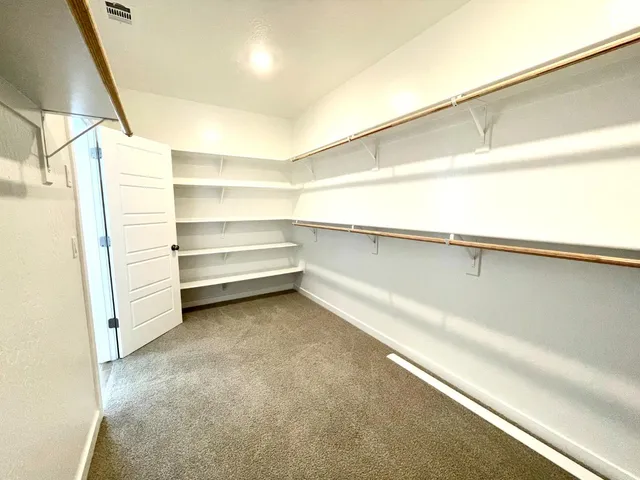 a view of walk in closet with empty racks