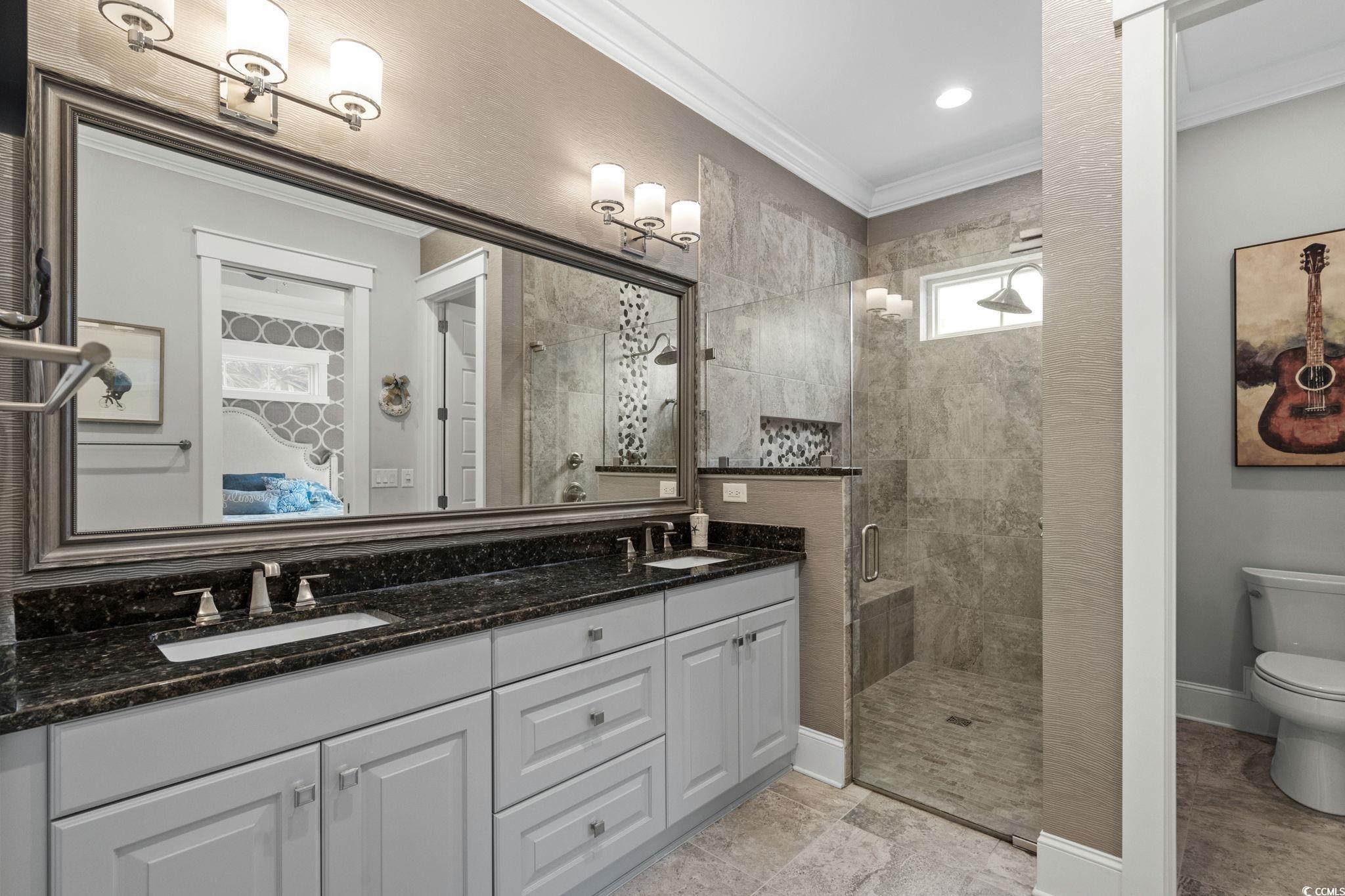 8245 Sandlapper Way Myrtle Beach, SC 29572 - Photo 22 of 40 Full bath featuring a tiled shower, double vanity, and ornamental molding