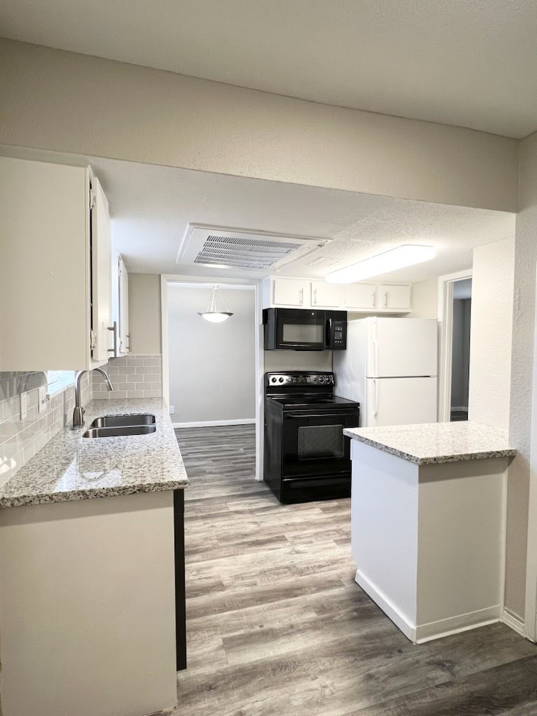 a kitchen with stainless steel appliances granite countertop a refrigerator sink and stove