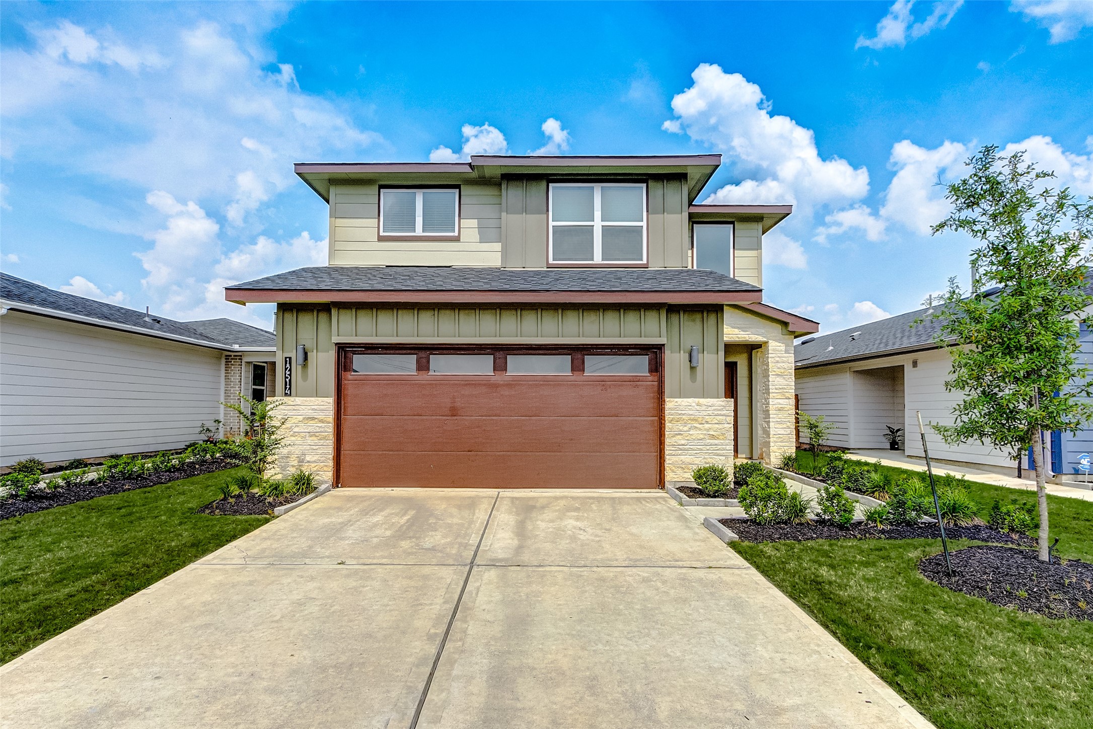 a front view of a house with a yard and a garage