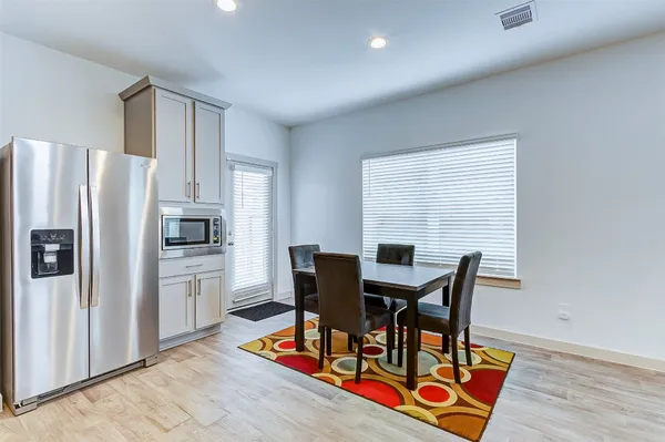 a view of a dining room with furniture and a refrigerator
