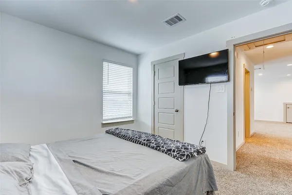 a bedroom with a bed and a flat screen tv