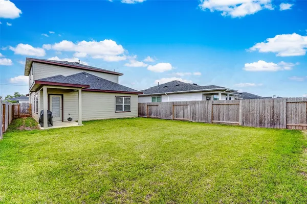a view of a house with backyard and wooden fence