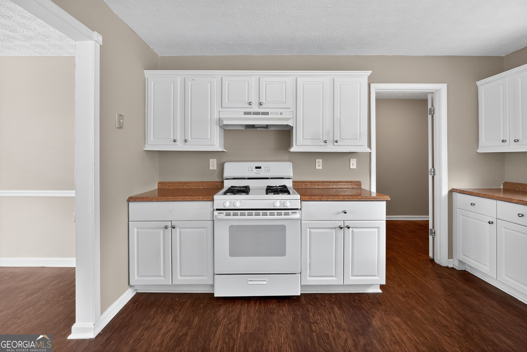 2391 Harmony Ridge Court Lithonia, GA 30058 - Photo 14 of 35 a kitchen with white cabinets white stainless steel appliances and wooden floors