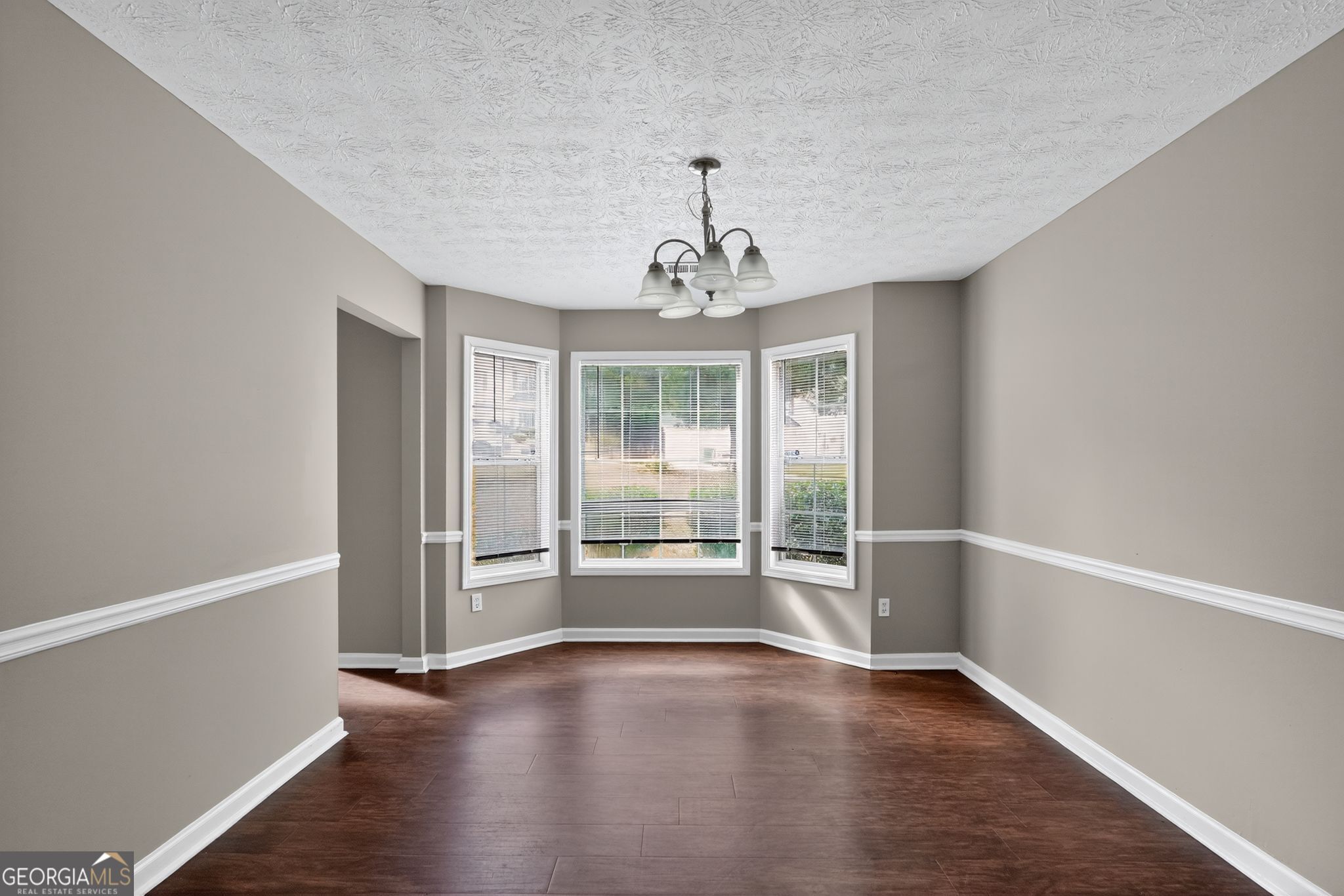 2391 Harmony Ridge Court Lithonia, GA 30058 - Photo 18 of 35 an empty room with wooden floor and windows