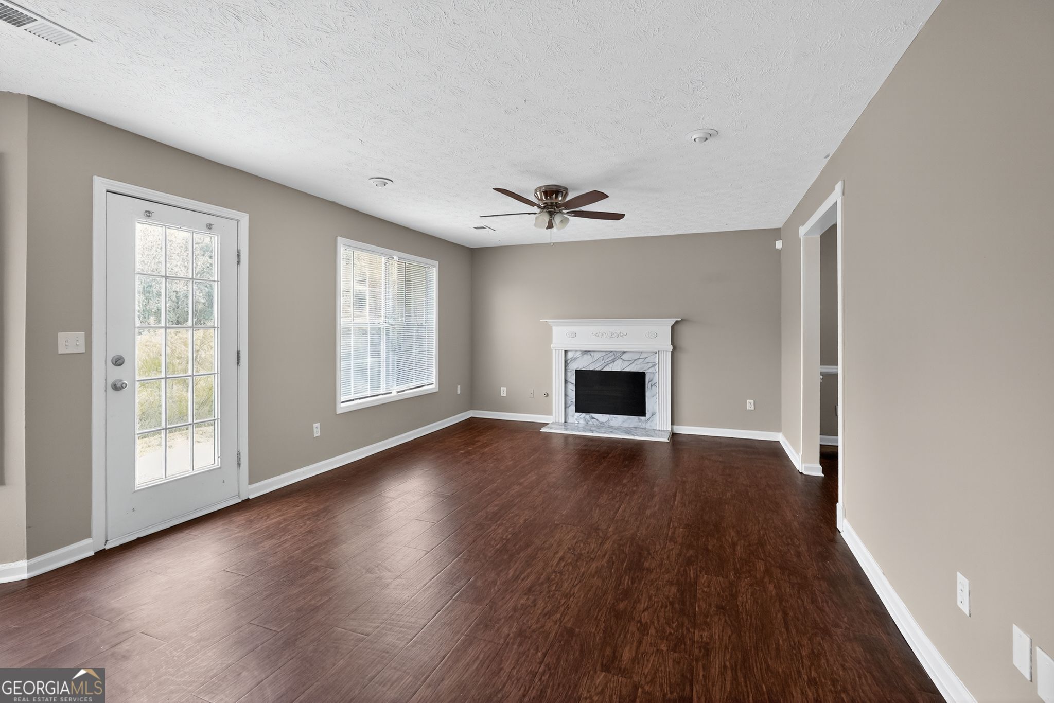 2391 Harmony Ridge Court Lithonia, GA 30058 - Photo 7 of 35 an empty room with wooden floor fireplace and windows