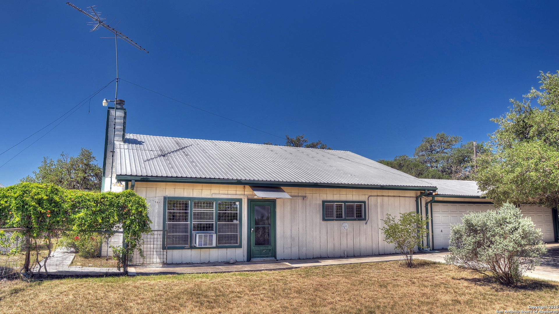 227 Mitchell Ranch Road Camp Wood, TX 78833 - Photo 3 of 72 a front view of a house with a garden