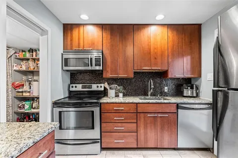 a kitchen with stainless steel appliances granite countertop a stove a refrigerator and a microwave