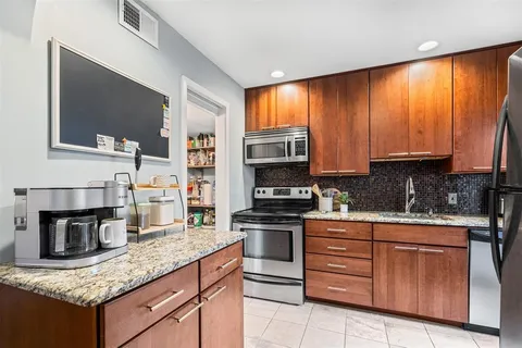 a kitchen with stainless steel appliances granite countertop a stove microwave and cabinets