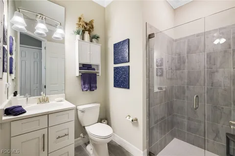 a bathroom with a sink toilet a mirror a vanity and shower