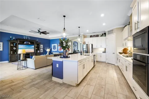 a large white kitchen with stainless steel appliances granite countertop a stove and cabinets