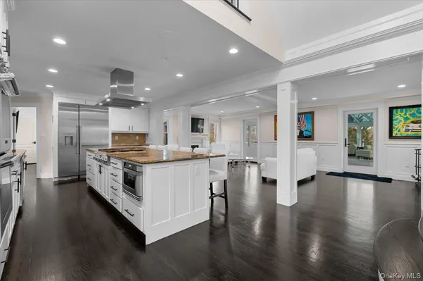 a large white kitchen with a large counter top appliances and cabinets