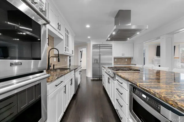 a large kitchen with stainless steel appliances granite countertop a lot of counter space