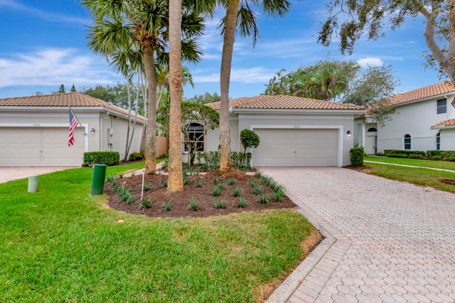 a front view of a house with a yard and potted plants