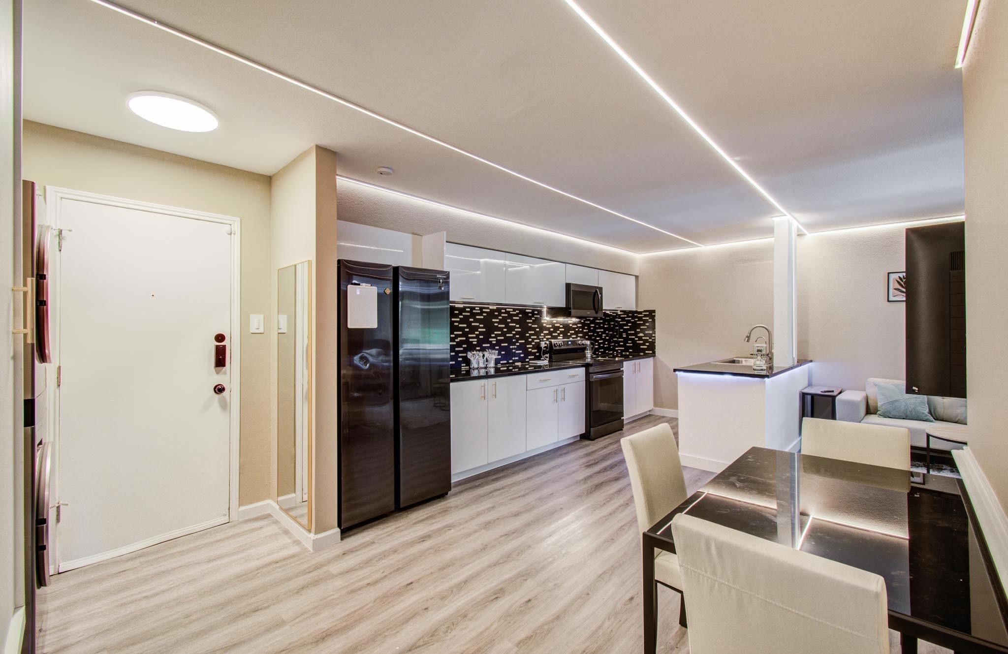 a kitchen with a refrigerator and white cabinets