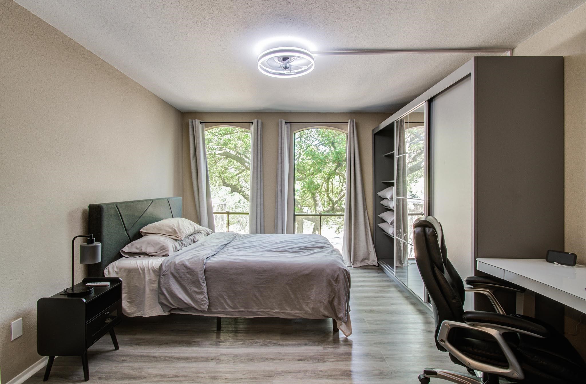 4641 Wild Indigo Street, Unit 433 Houston, TX 77027 - Photo 7 of 21 a bedroom with a bed a flat screen tv and a large window