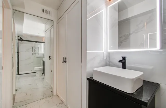 a bathroom with a sink shower and a mirror