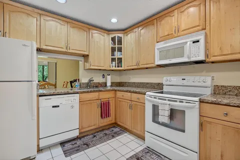 a kitchen with granite countertop cabinets stainless steel appliances and a sink
