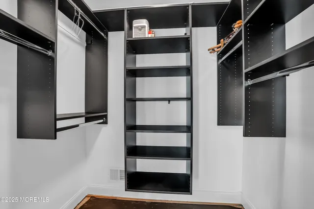 a view of walk in closet with empty racks