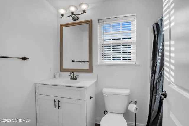 a bathroom with a sink a toilet and a mirror