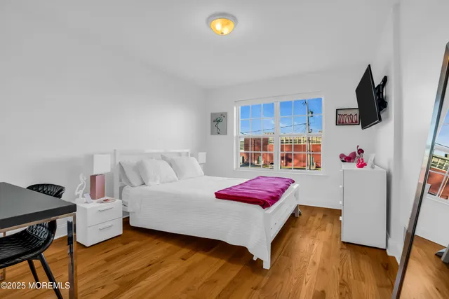 a bedroom with furniture and a flat screen tv