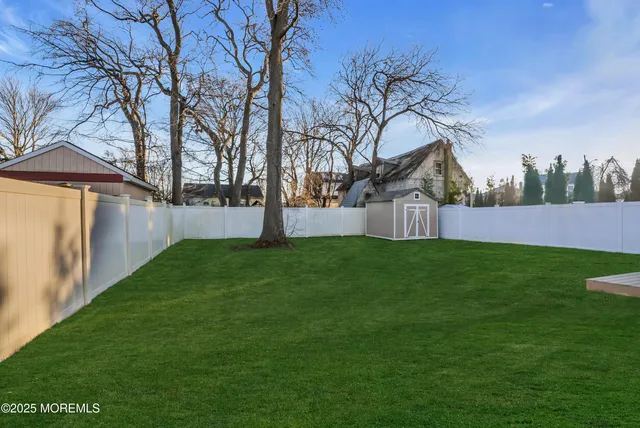 a view of an house with backyard and trees
