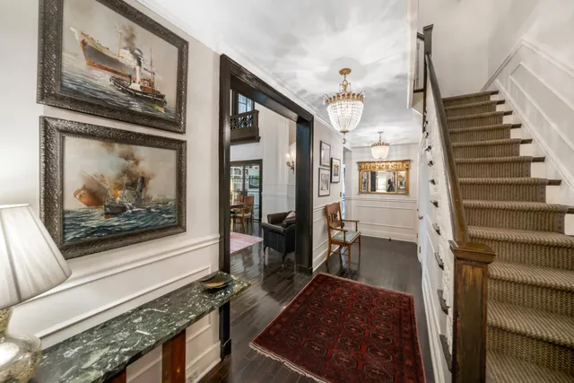 a view of a hallway with wooden floor and staircase
