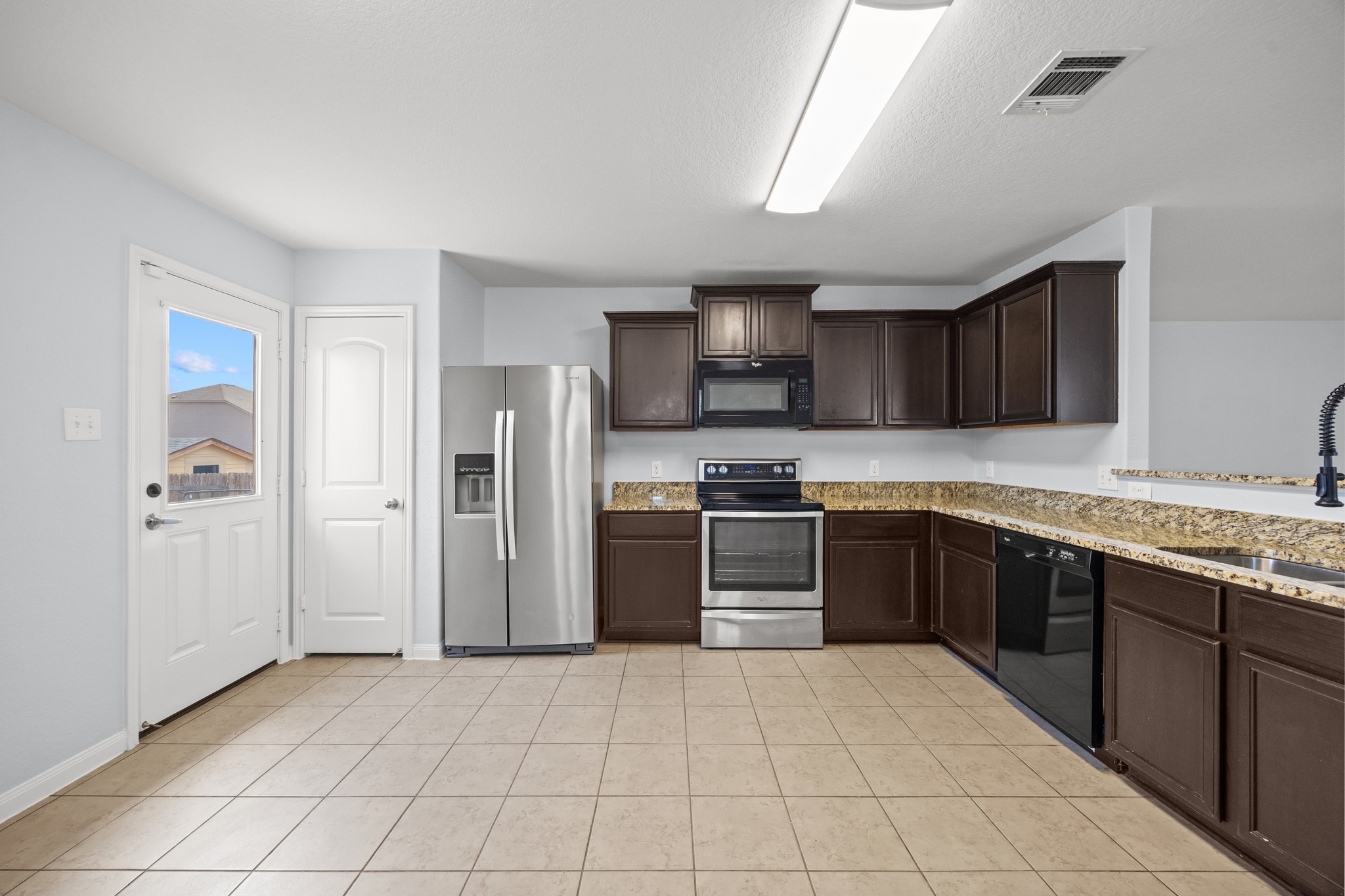 228 Millers Loop Jarrell, TX 76537 - Photo 17 of 26 Rich dark cabinetry pairs with granite countertops and tile flooring in this functional culinary space.