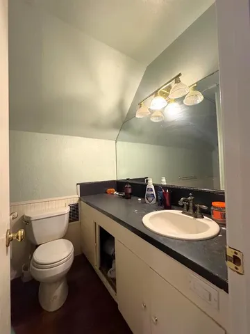 a bathroom with a toilet sink and mirror