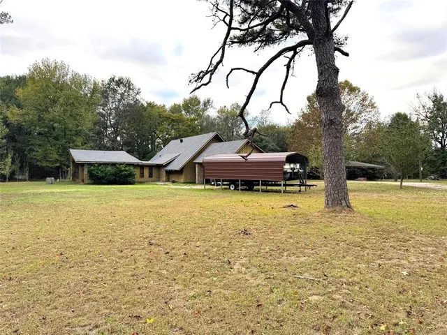 a backyard of a house with table and chairs