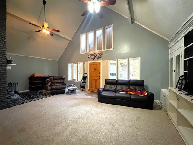 a living room with furniture a chandelier a fireplace and a flat screen tv