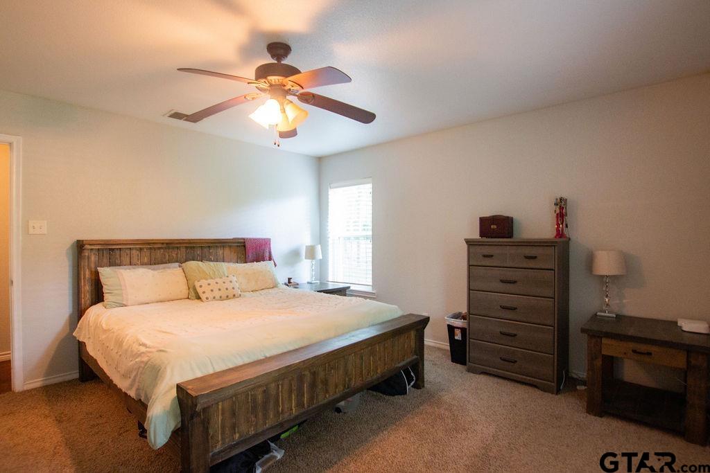 2110 Inwood Circle Tyler, TX 75701 - Photo 14 of 44 a bedroom with a bed a chandelier and a dresser