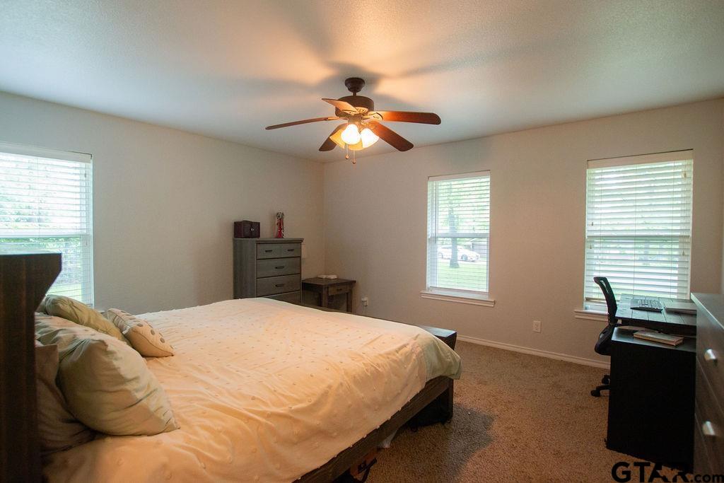 2110 Inwood Circle Tyler, TX 75701 - Photo 15 of 44 a bedroom with a bed and a chandelier