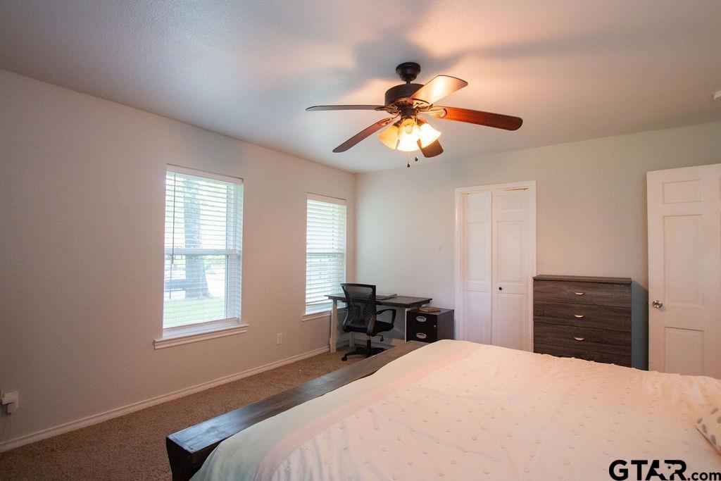 2110 Inwood Circle Tyler, TX 75701 - Photo 16 of 44 a bedroom with a bed and a chandelier